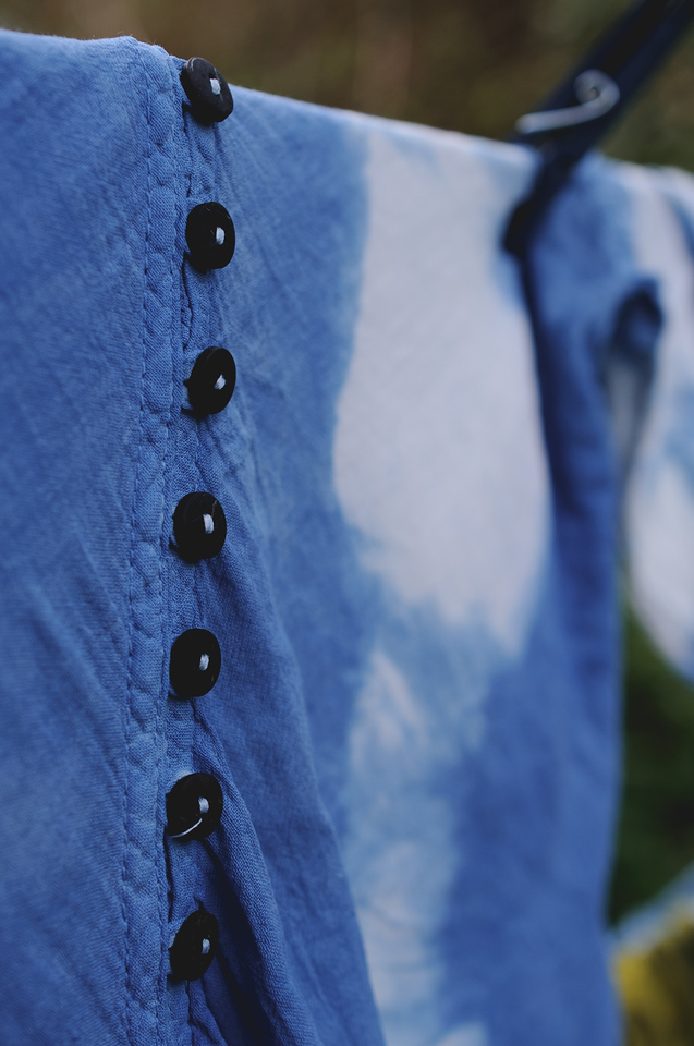 Blue tie-dye fabric with a row of black buttons